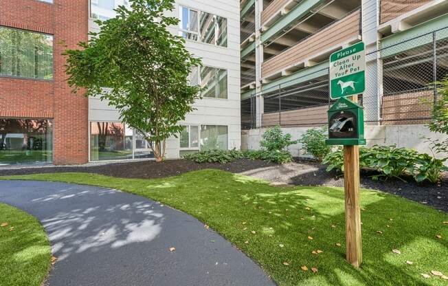 a walkway in front of an apartment building with a green pedestrian crossing sign