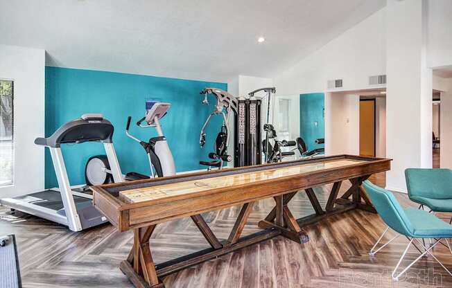 A gym with a treadmill, elliptical trainer, and other exercise equipment.