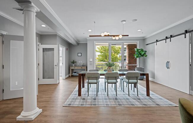 Resident coworking lounge with a large gathering table, natural light, and flexible seating.