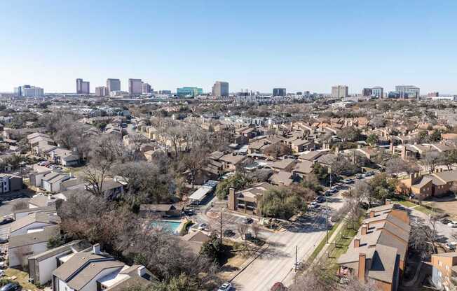 A residential area with houses and a city skyline in the background.