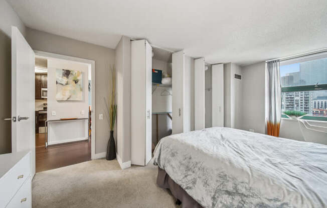 A bedroom with a large bed and a view of the city.