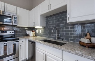 a kitchen with white cabinets and a sink