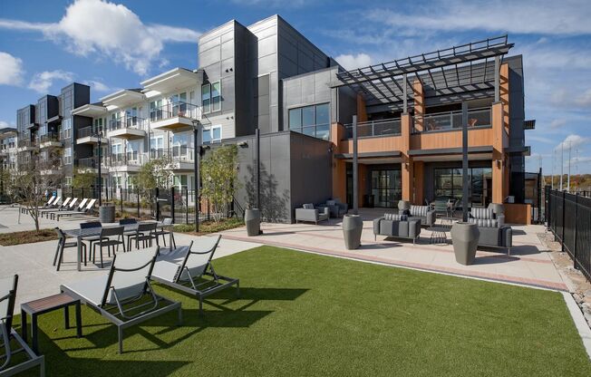 a rendering of a building with lawn chairs and tables