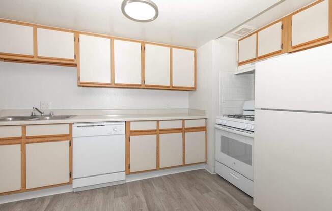 A kitchen with white appliances and wooden cabinets.