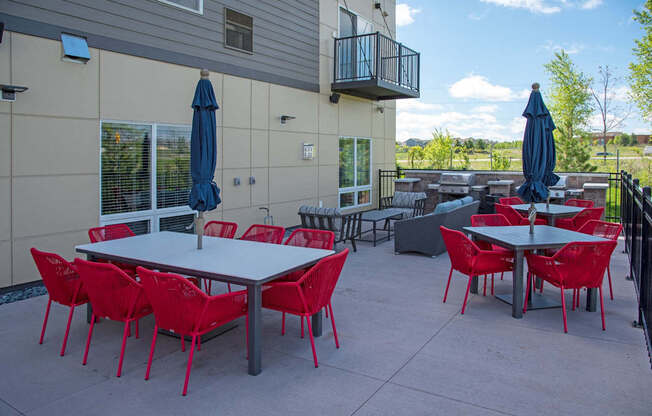 A patio with red chairs and tables.