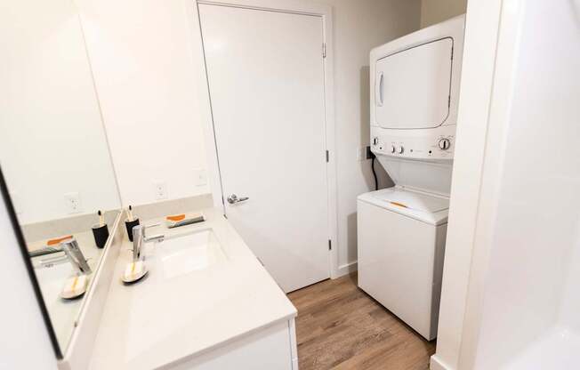 a small bathroom with a sink and a washer and dryer in a room