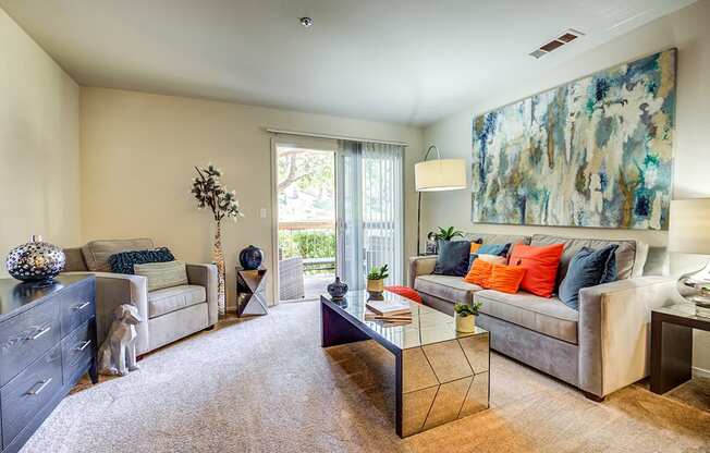 Pet-Friendly Apartments in Richmond CA - Bella Vista at Hilltop - Living Room with Fireplace, Plush Carpeting, and Attached Private Patio