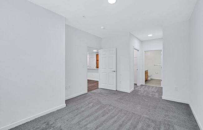 a living room with a rug and a door to a bathroom