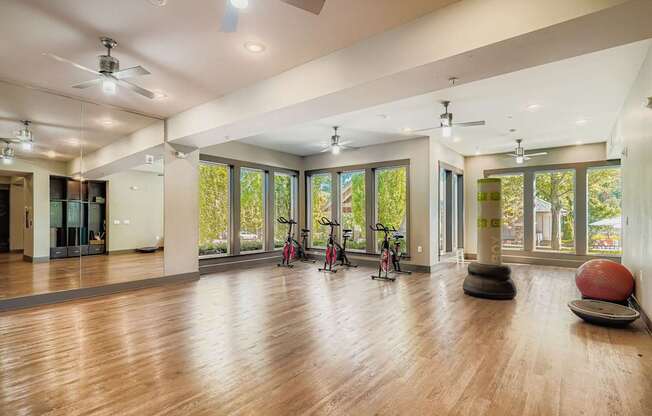 A spacious room with wooden floors and a ceiling fan.