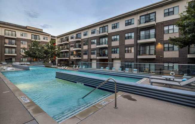 A swimming pool in front of apartment buildings.