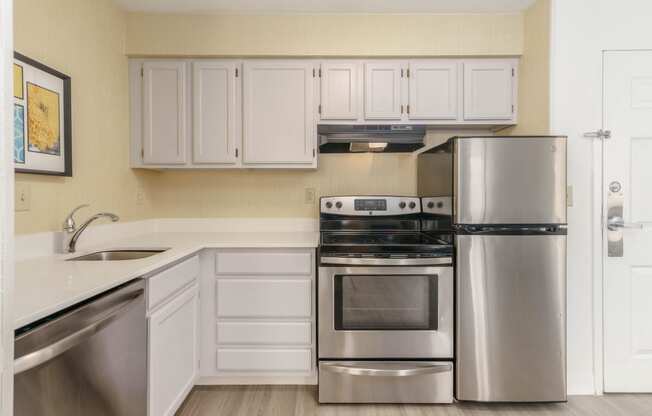 a kitchen with stainless steel appliances and white cabinets