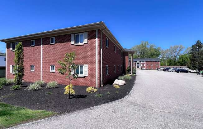 A red brick building with a parking lot in front.