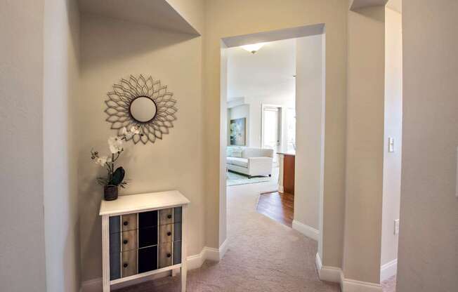 A hallway with a white console table and a mirror on the wall.