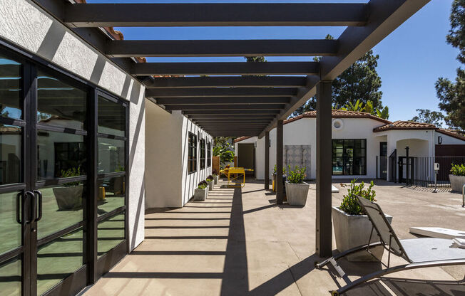 a patio with chairs and awnings in front of a building at La Jolla Blue, California, 92122