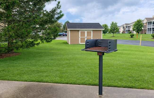 A mailbox sits on a pole in front of a green lawn.