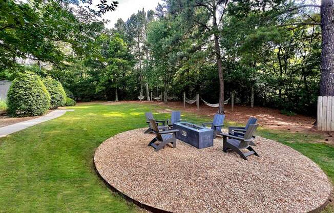 a fire pit and seating area in the backyard of a home
