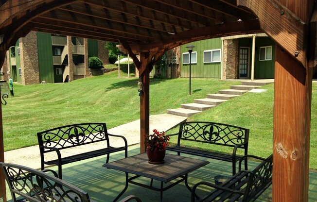 a covered patio with a table and benches
