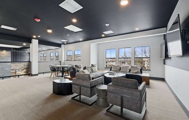 a community room with couches and chairs and a table and a tv  a c