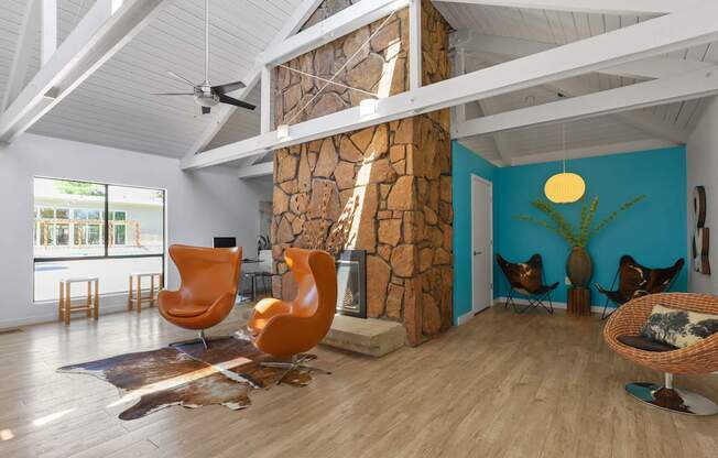 A room with a stone fireplace and wooden floors.