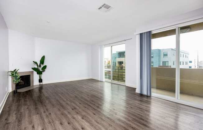 a living room with white walls and wood floors and a fireplace