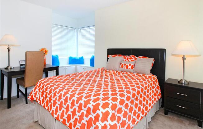 Bed with orange bedspread.