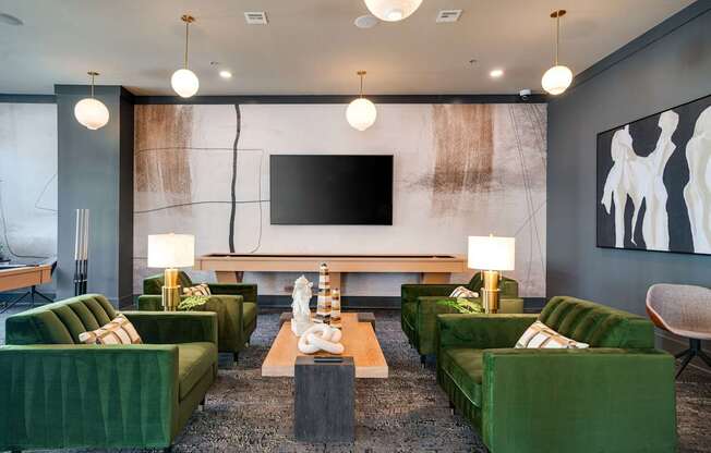 a large living room with green couches and chairs and a television
