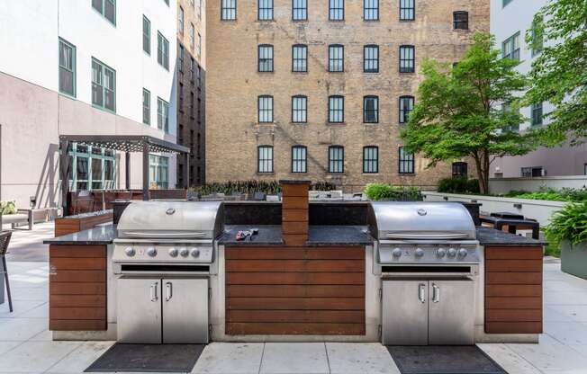 the outdoor kitchen has stainless steel appliances and a grill and a bar with a wood
