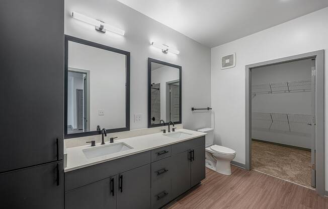 a black and white bathroom with two sinks and a toilet