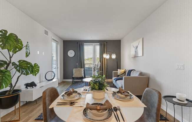 Dining area with a table and chairs and a living room with a couch and a window at Array La Mesa, La Mesa California