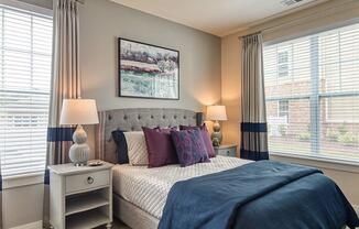 a bedroom with a bed and two windows  at Sapphire at Centerpointe, Midlothian