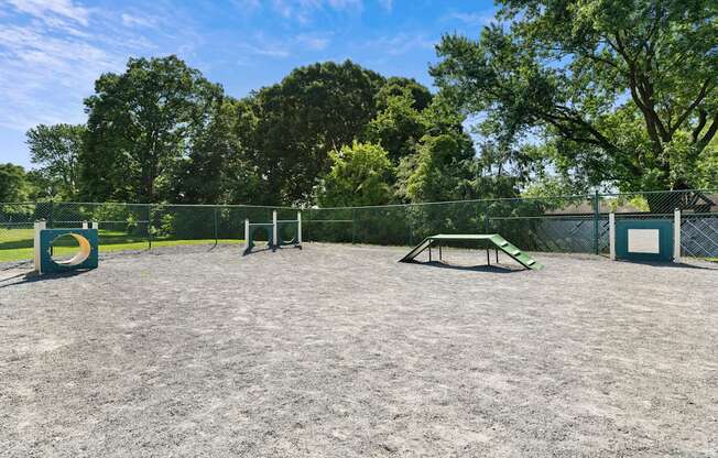 A park with a picnic table and a fence.
