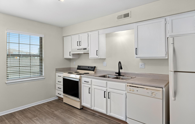 Gold kitchen interior with appliances at The Arbor Apartments in Blue Springs, Missouri