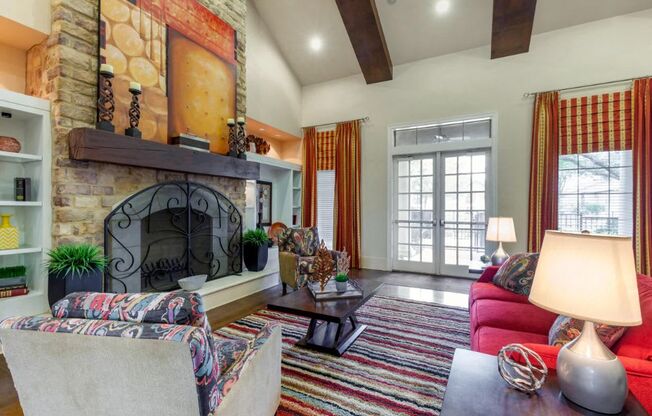 Clubhouse Interior with red and orange accents, a red sofa, orange curtains, two accent chairs, and a striped rug