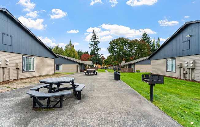 A picnic table is in the middle of a courtyard between two apartment buildings.