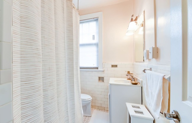 bathroom with toilet, tub, vanity and mirror at the foreland apartments in washington dc