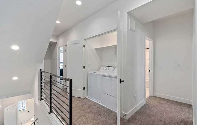 a hallway with a laundry closet with washer and dryer