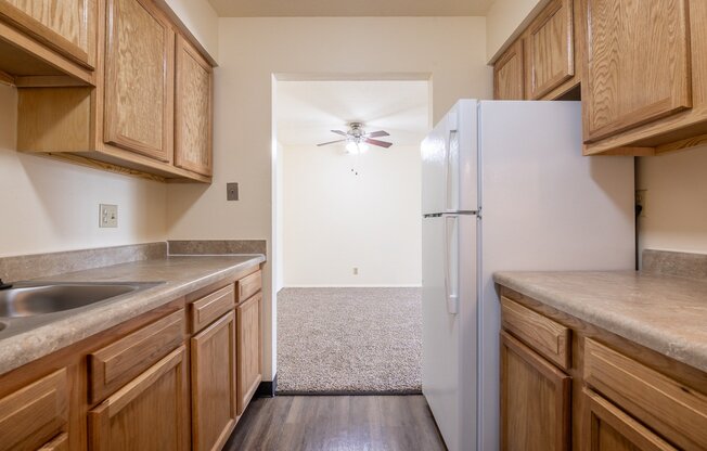 A kitchen with wooden cabinets and a white refrigerator.
