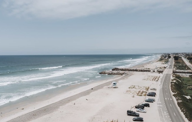 a view of the beach and the road next to the ocean