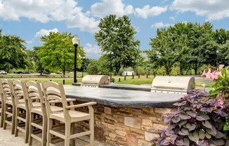 a patio with chairs and a stone wall and a pool