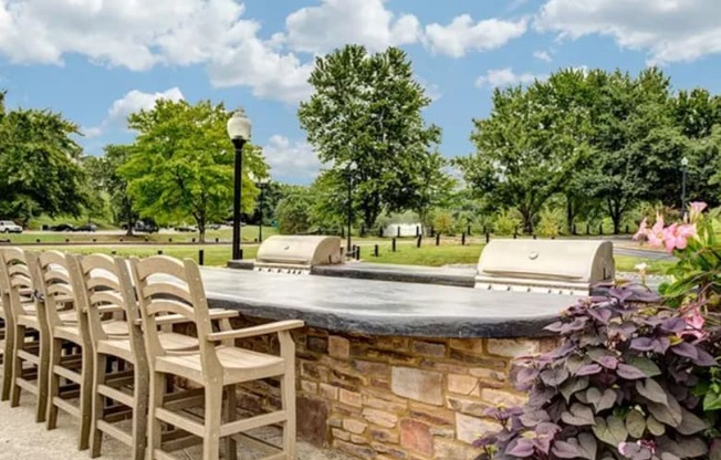 a patio with chairs and a stone wall and a pool