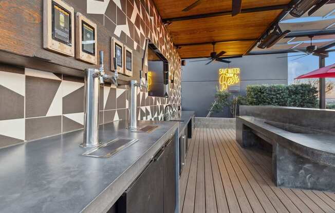 A modern bar with a wooden floor and a metal counter.
