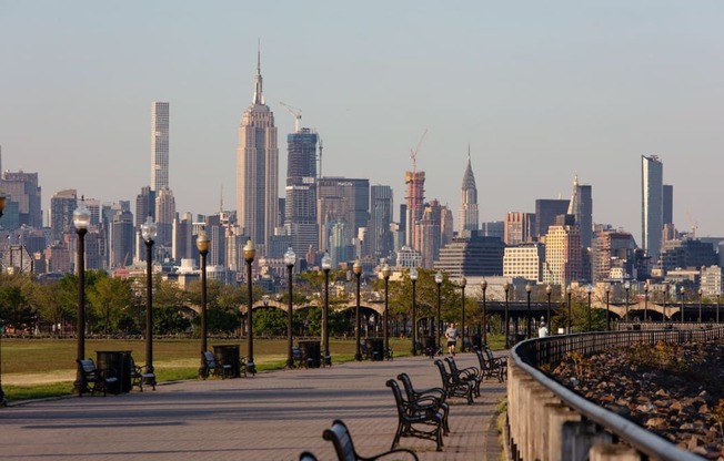 a view of the city skyline from a park with benches at One Ten Apartments, Jersey City , NJ, 07310