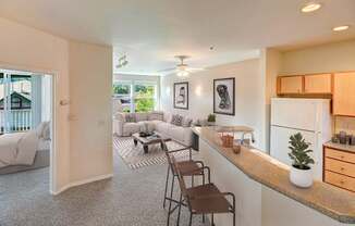 A well-lit, modern kitchen and living room with a dining area.