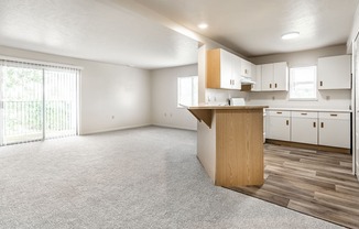 A spacious kitchen with white cabinets and a wooden island