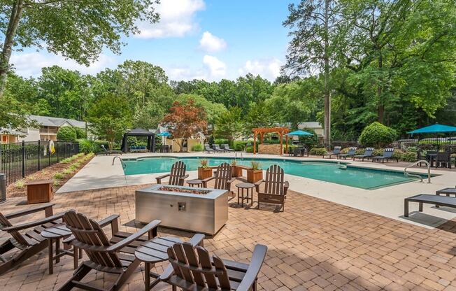 a swimming pool with patio furniture and a fire pit
