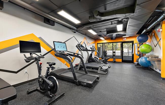 a gym with cardio equipment and weights in a building at Troy Place Apartments - Troy, MI, Troy, Michigan