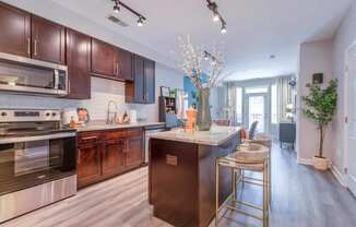 a kitchen with dark wood cabinets and stainless steel appliances
