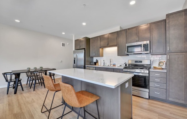 a kitchen with a large center island with a white quartz top