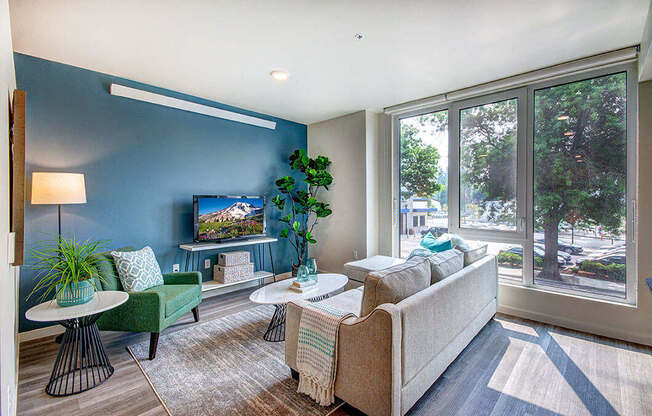 A living room with a couch, chair, and television. at Ravello Apartments, Redmond, WA