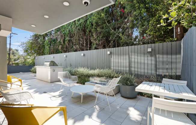 a patio with a table and chairs and a privacy fence
